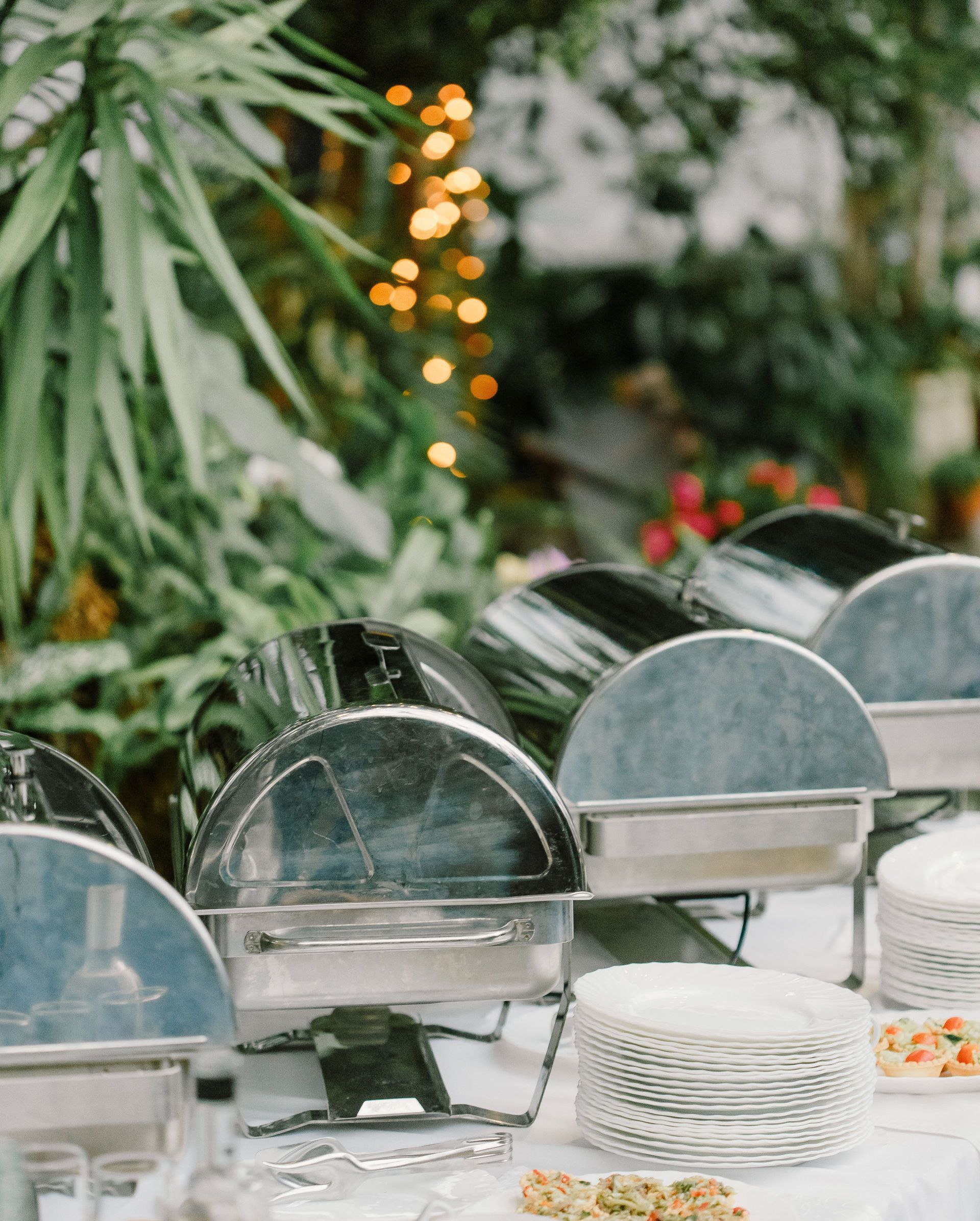 Buffet table with various food and appetizers placed on white tablecloth in outdoor restaurant