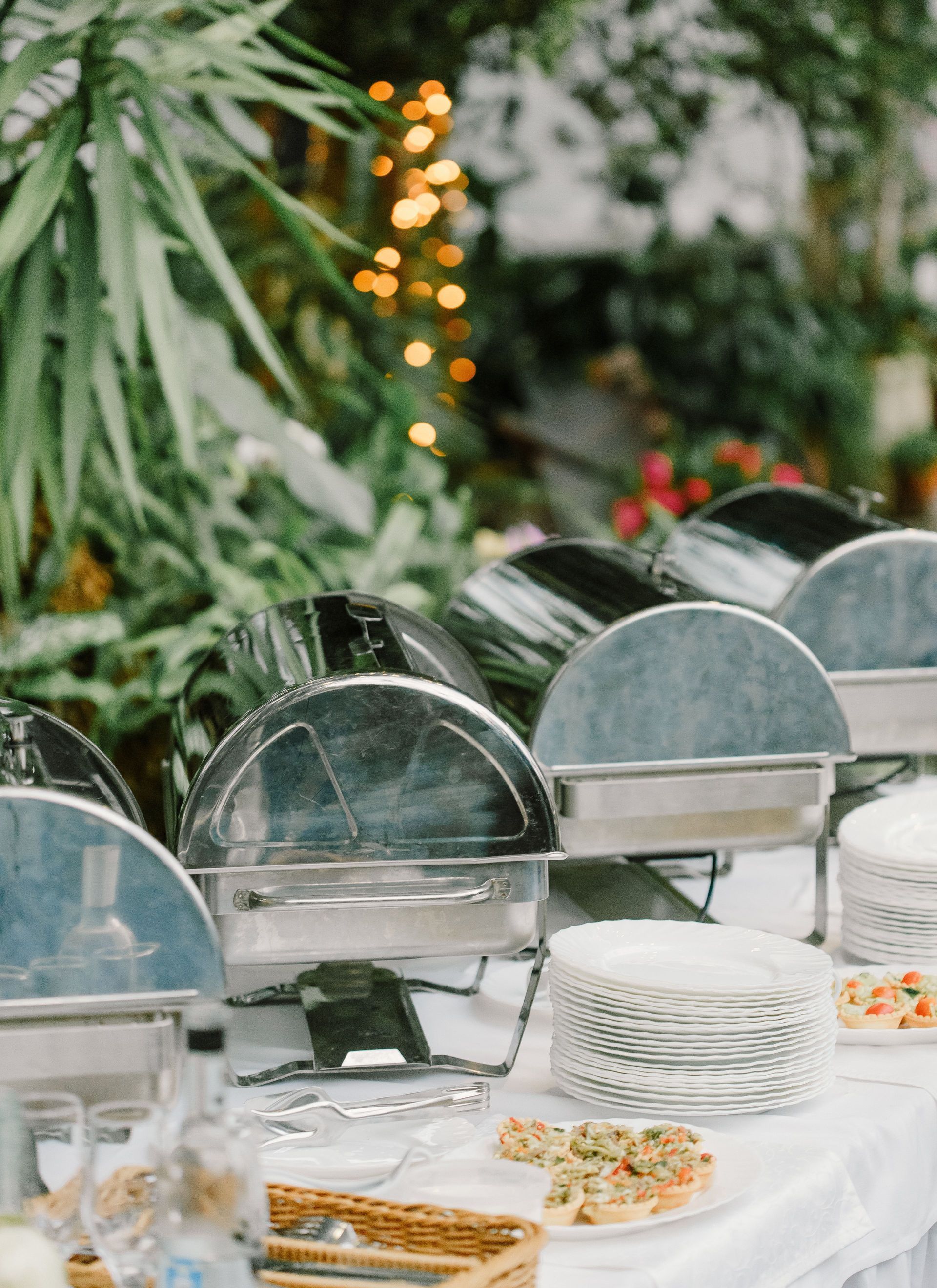 Buffet table with various food and appetizers placed on white tablecloth in outdoor restaurant