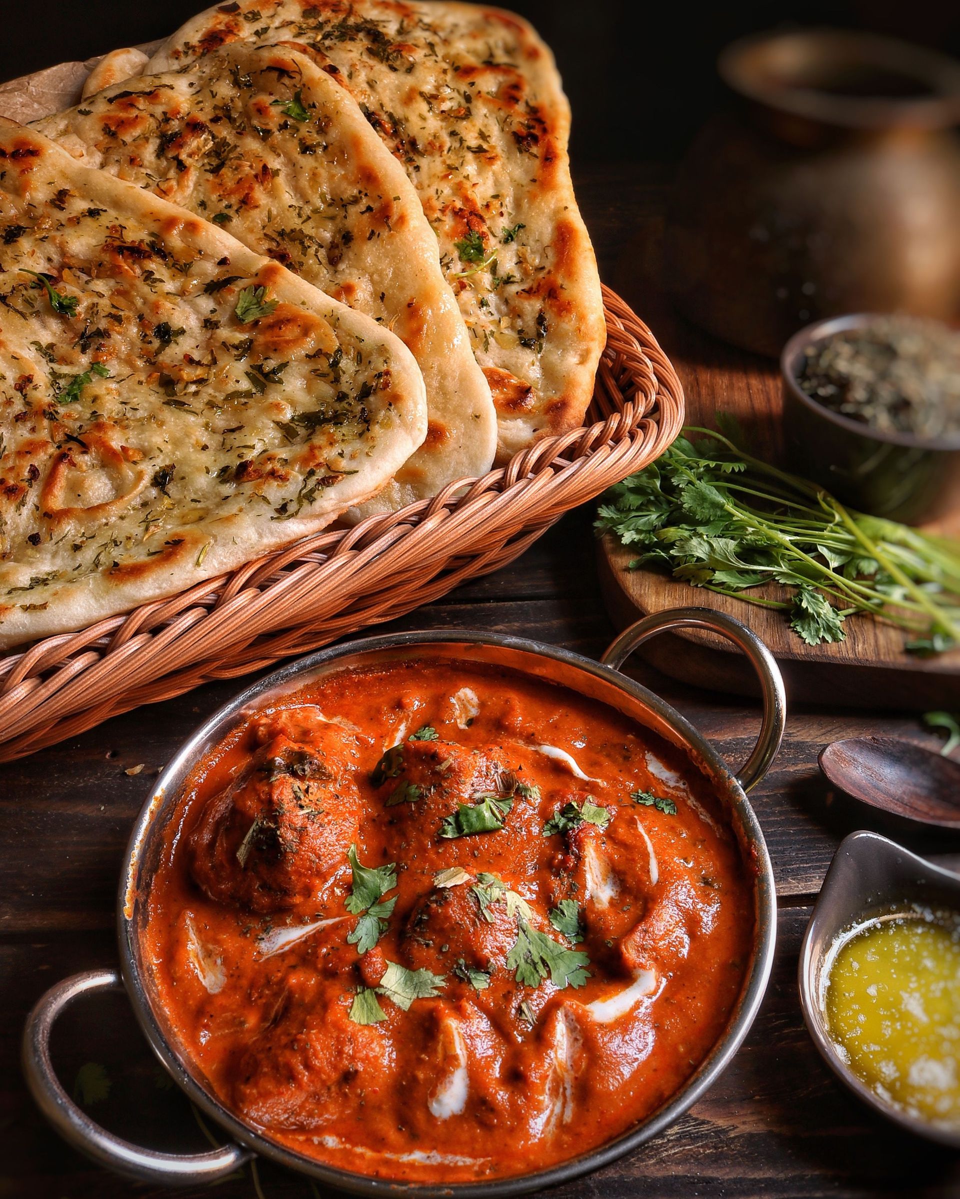 Close-up of flavorful butter chicken with garlic naan, capturing the essence of Indian cuisine.